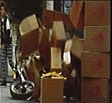 Frame from The Punk: a motorbike crashes through a stack of boxes