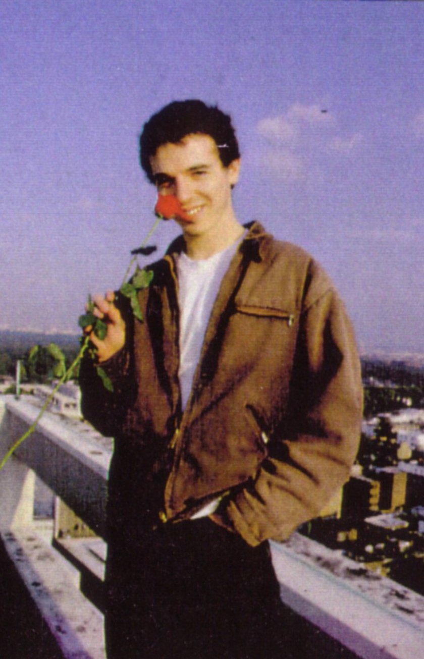 David on a tower block roof above London, holding a red rose