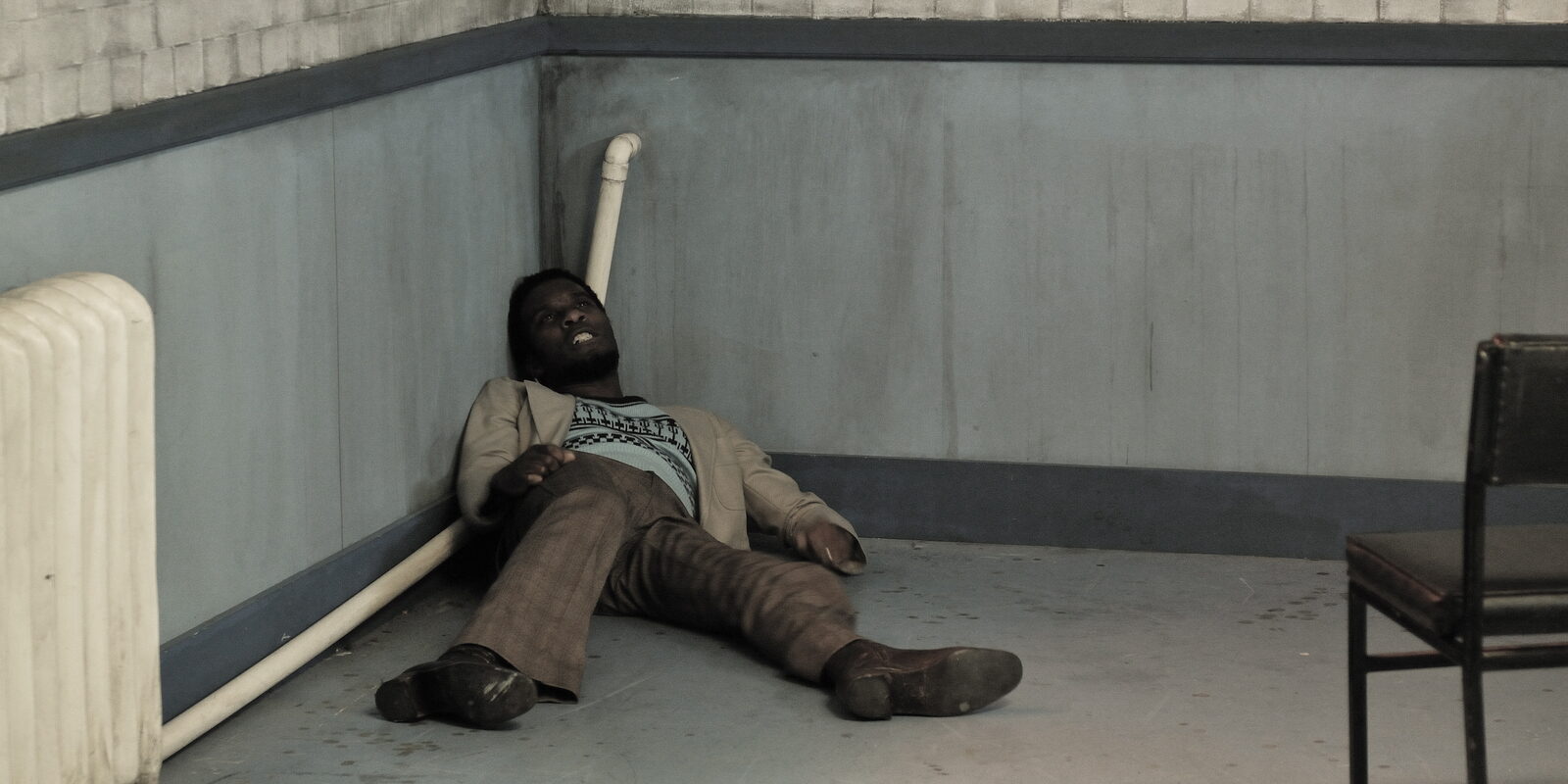 Delroy lying on the floor of the interview room