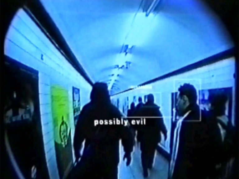 Surveillance view of a crowded underground passage, a figure tagged possibly evil