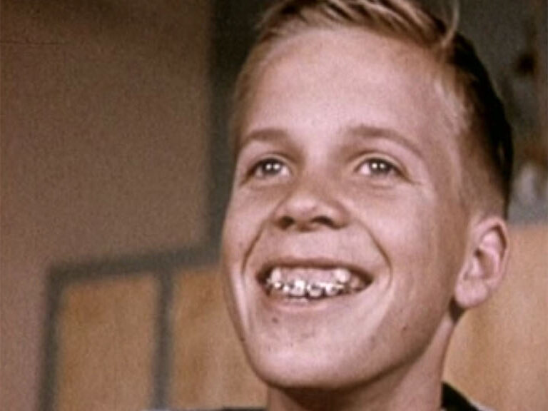 A boy with a wide grin, 1950s colour film